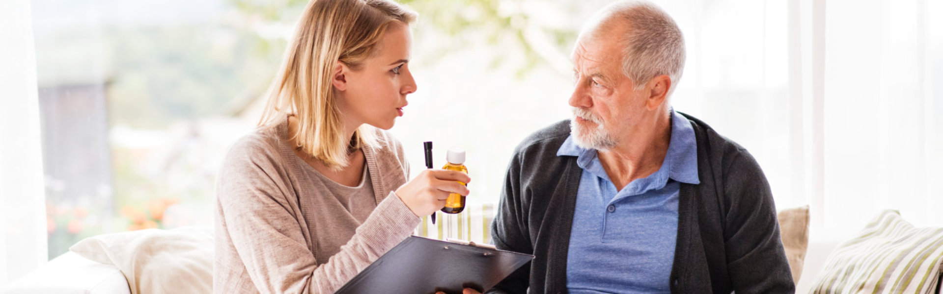 caregiver and elderly man sitting and talking to each other